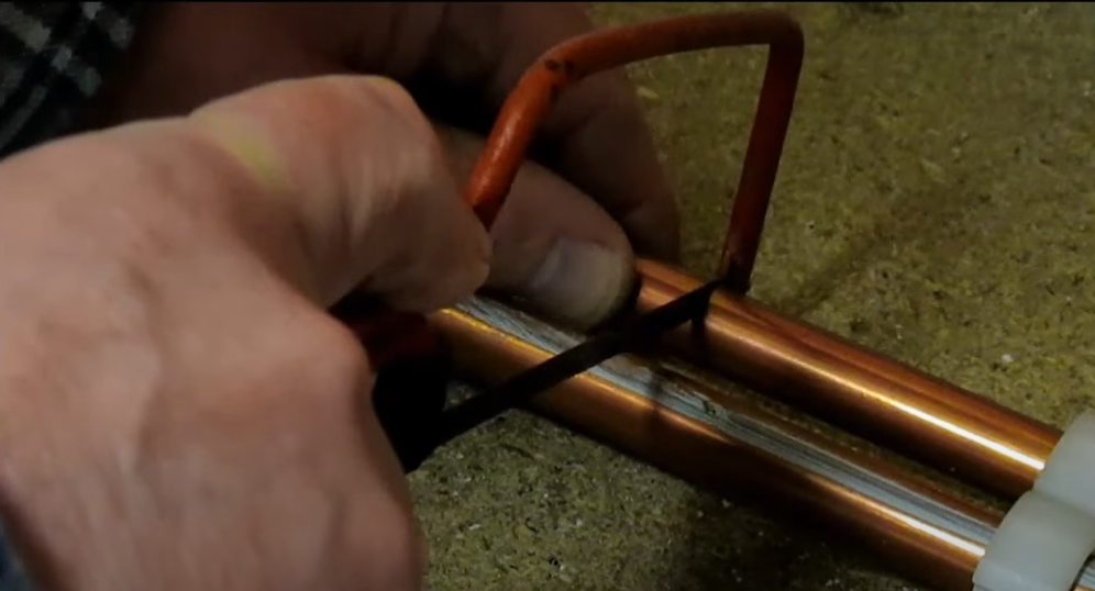 Cutting copper pipe with hacksaw